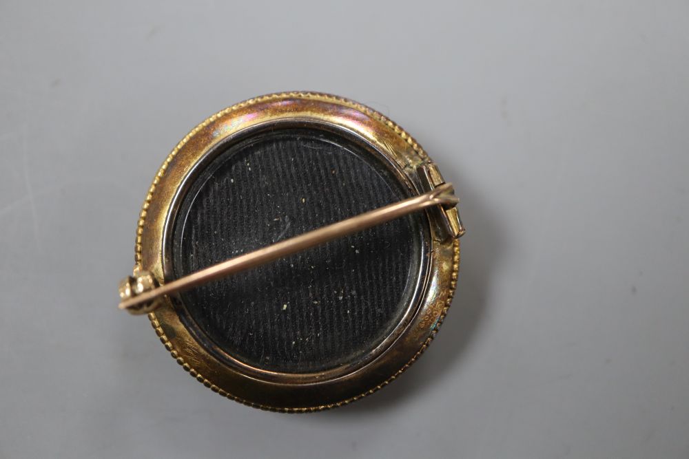 A Victorian yellow metal and diamond set circular brooch, with glazed back, 32mm, gross 10.3 grams.